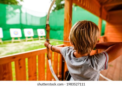 8 year old boy playing archery with bow and arrow