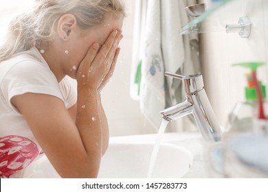 8 Year Old Girl Washes Her Face In The Bathroom In The Morning