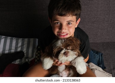 8 Year Old Sitting On An Open Suitcase With A Shih Tzu Puppy On Her Lap_top View.