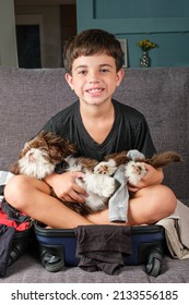 8 Year Old Sitting On An Open Suitcase With A Shih Tzu Puppy On Her Lap.