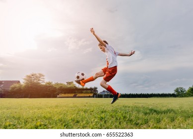 8 years old boy child playing football on playing field. Child playing football
