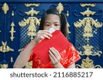 8 Years old Happy Asian cute girl wearing Chinese red dress, holding Red envelope or Hong bao or Cheongsam. Chinese new year concept.