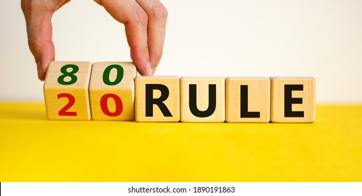 80 on 20 rule symbol. Pareto principle. Male hand flips wooden cubes with words '80 on 20 rule'. Beautiful yellow table, white background, copy space. Business and 80 on 20 rule, pareto concept.