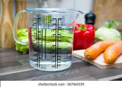 800ml / 8dl Of Water In A Measuring Cup On A Kitchen Counter With Vegetables