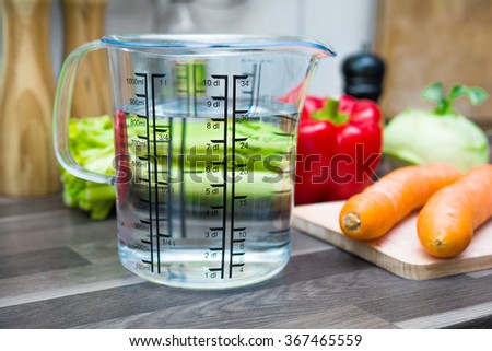 800ml / 8dl Of Water In A Measuring Cup On A Kitchen Counter With Vegetables