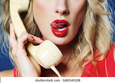 
80s Style Sexy Blonde Woman Phoning Erotic Phone Call With Vintage Phone On Studio Isolated Blue Background