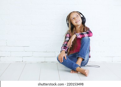 8-9 years old stylish teen girl with black headphones posing on white background