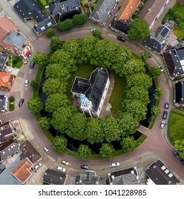 9 July 2016, Spijk, Holland. Aerial view of Andreaskerk in the province of Groningen, Holland. The church is built on a terp or mound and is surrounded by large green trees in a circle shape. - Shutterstock ID 1041228985