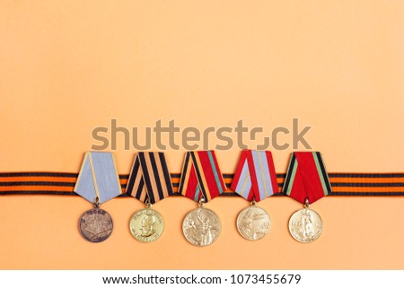 9 May background. St George's ribbon and medals of Great patriotic war on orange
background. Heirloom. 