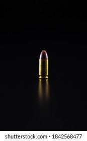 A 9 Millimetre Bullet Placed On A Black Background