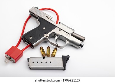 9 Mm.Bullets  With Locked Disarmed And Secured Automatic Hand Gun On White Background , Gun Safety Concept