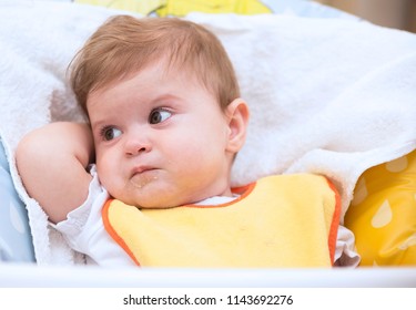 The 9 month old baby is looking angry and refuses to eat meal. Baby feeding and baby behaviour concept