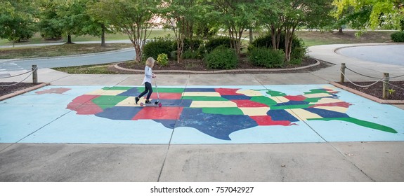 A 9 Year Old Girl Riding A Scooter Across A Map Of The United States