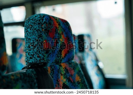 90s 80s style pattern plush velvety fabric of bus seats abstract bright colorful design with headrest buckle
belt 