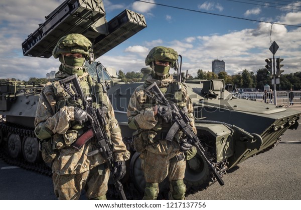 9/16/2017 Russia, Moscow. A military forum\
Army-2017 on city streets near the Ministry of Defence. Two\
soldiers in a camouflage up in arms. the modern infantry fighting\
vehicle on a\
background