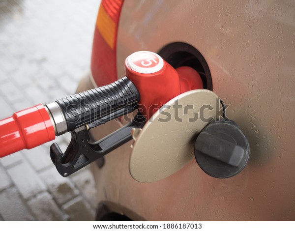 A 95 fuel delivery gun nozzle inserted into the\
car tank at a gas station