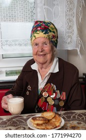 98-year-old War Veteran Old Woman In A Suit With Medals And Orders Eats While Sitting At A Table