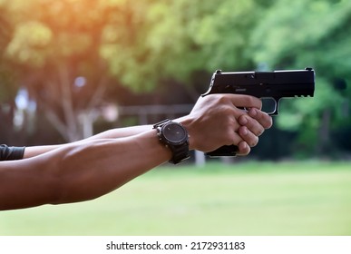 9mm Automatic Pistol Gun Holding In Hand Of Gun Shooter, Blurred Shooting Range Background, Concept For Security Training By Using Pistol Gun To Save And To Protect Human Life And Human's Property.