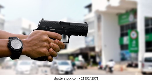 9mm Automatic Pistol Holding In Hands Of Shooter, Blurred Bank Background, Concept For Security, Bank Robbery, Gangster, Bodyguard Around The World. Selective Focus On Pistol.