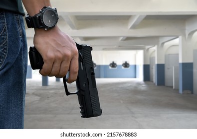 9mm automatic pistol holding in right hand of shooter at the shooting range, concept for security, robbery, gangster, bodyguard training. selective focus on pistol.