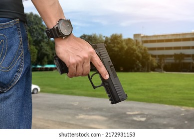 9mm automatic pistol holding in right hand of shooter, concept for security, robbery, bodyguard, gangsters, mafias, and police officers around the world. selective focus on pistol.