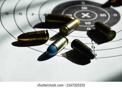 9mm Bullets And 9mm Bullet Case On Shooting Target Paper, Soft And Selective Focus.