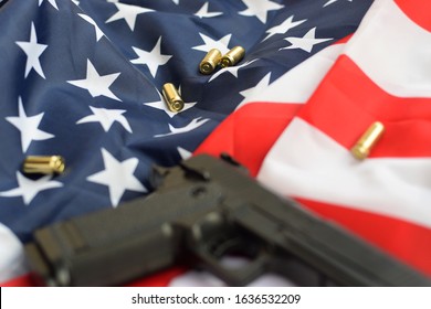 9mm bullets and pistol lie on folded United States flag