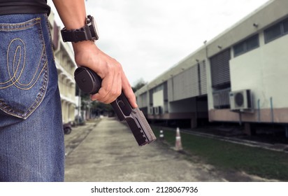 9mm pistol gun holding in right hand of gun shooter, blurred home background, concept for home security, body guard, gangster, mafias and vip protection in resident area around the world.