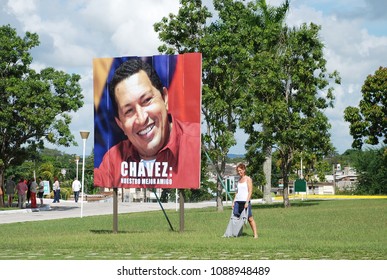 9th Of November 2013 - Scene From The Lawn In Front Of The Che Guevara Mausoleum With A Young Woman Beside A Big Poster Of Hugo Chávez, Santa Cloara, Cuba