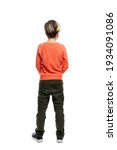 A 9-year-old boy stands in jeans and an orange sweater. Full height. Isolated on a white background. Vertical. Back view.