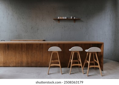 "A cozy, vintage-style cafe with a wooden counter and minimalist decor. The warm interior features modern furniture, coffee cups on a rustic table, and a serene atmosphere, perfect for a relaxed lifes - Powered by Shutterstock