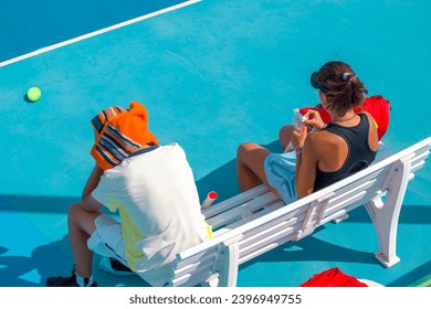 .A young girl tennis player is resting  in between games   - Powered by Shutterstock