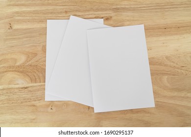 Eine 4-fach-Broschüre mit weißer Blankovorlage für Muster und Präsentationen auf Holzoberfläche. 