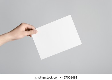 A5 Flyer / Invitation Mock-Up - Male hands holding a blank flyer on a gray background.