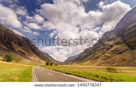 The A82 road crosses pasture fields in the valley floor of Glen Coe, under the mountains of the West Highlands of Scotland. Stock photo © 