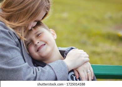 AA Young Happy Boy Hugging His Mom. Mom Hugs Her Son. Family In The Park