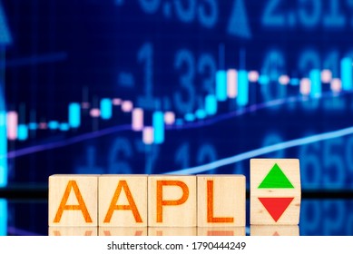 aapl. wooden cubes with the inscription aapl and a cube symbolizing the rise and fall of the financial market against the background of the stock chart