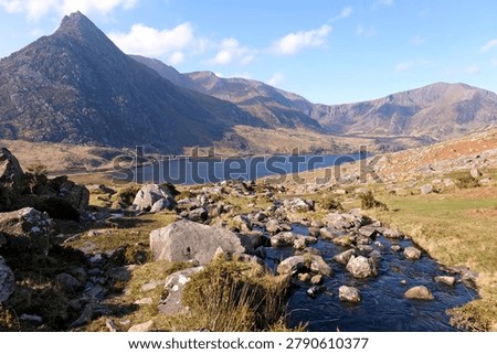 Aaron Lloer stream running down to Llyn Ogwen in Ogwen Valley with Tryfan peak and the Glyderau  range in the background, Eryri National Park, fomaly Snowdonia, North Wales, UK. 