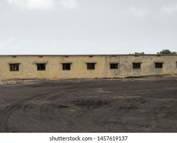 An abandon housing project near a coal yard under grey sky