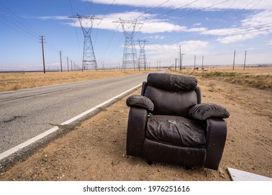 Abandon Recliner Chair Furniture on Desert Road with Power Lines in Dirt