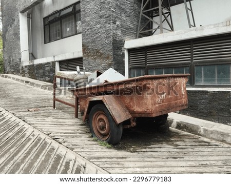 abandoned agricultural tractor wagon beside the building