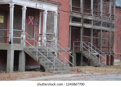 Abandoned and boarded up brick mental hospital asylum building 
