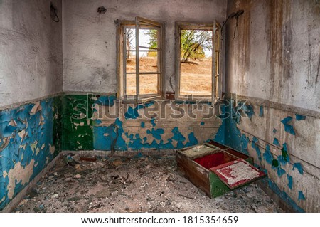 Abandoned border post on the border with Greece near the village of Gorno Lukovo - room with two windows without glass blue peeled plinth and a cupboard knocked to the ground