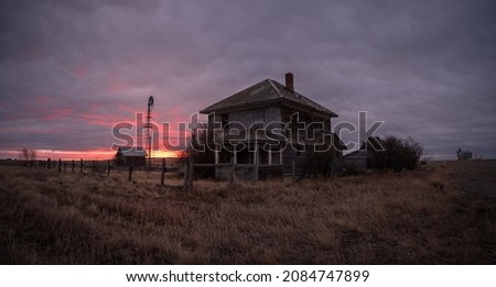 Abandoned and broken down old farms and homesteads with dark and ominous skies in Alberta, Canada