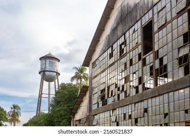 Abandoned building with broken windows and historic water tank tower of Fordlandia city village in Amazon rainforest, Brazil. Town built by Henry Ford in 1928.	