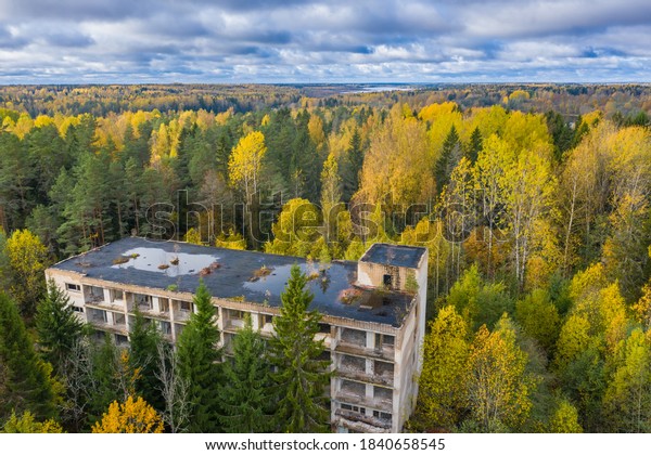 Abandoned building in middle of forest.\
Dilapidated building in autumn taiga. Abandoned house in Korela\
forest. Northern taiga with an old five-storey building. Top view\
of northern forest.