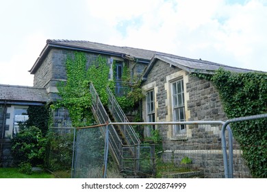 An Abandoned Building, Overgrown With Ivy, At A Former Hospital Site In West Wales, UK.