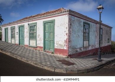 An Abandoned Building With A Rustic Appearance And Closed Doors And Windows With A Broken Streetlight In Front