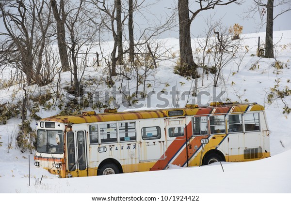 An\
abandoned bus by the road side in winter\
season.