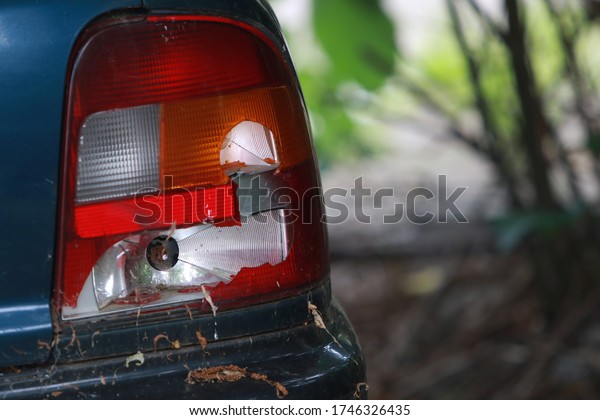 Abandoned car with broken windshield and\
side windows, flat tires and broken\
headlights\
